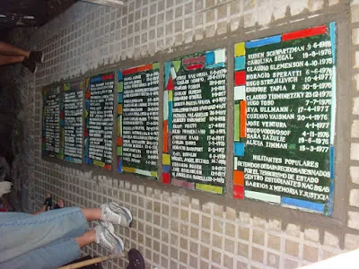 Placas con nombres y fechas, en la pared de la vereda del colegio.